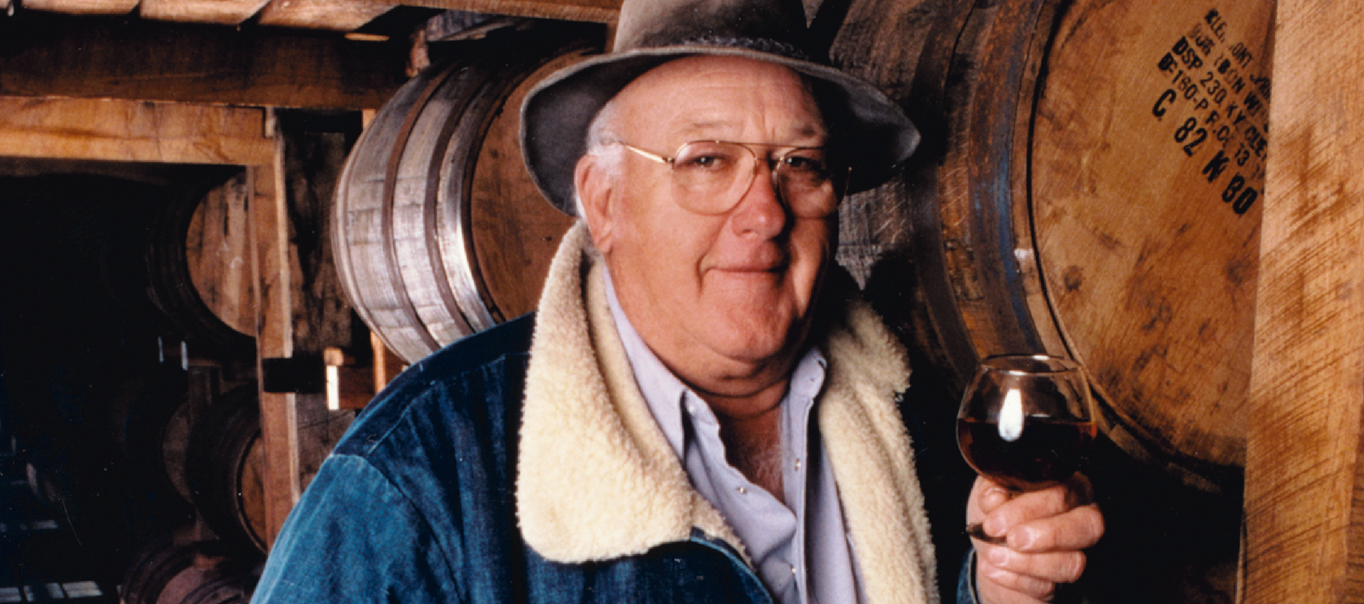 Image of James B. Beam  holding a glass of wine