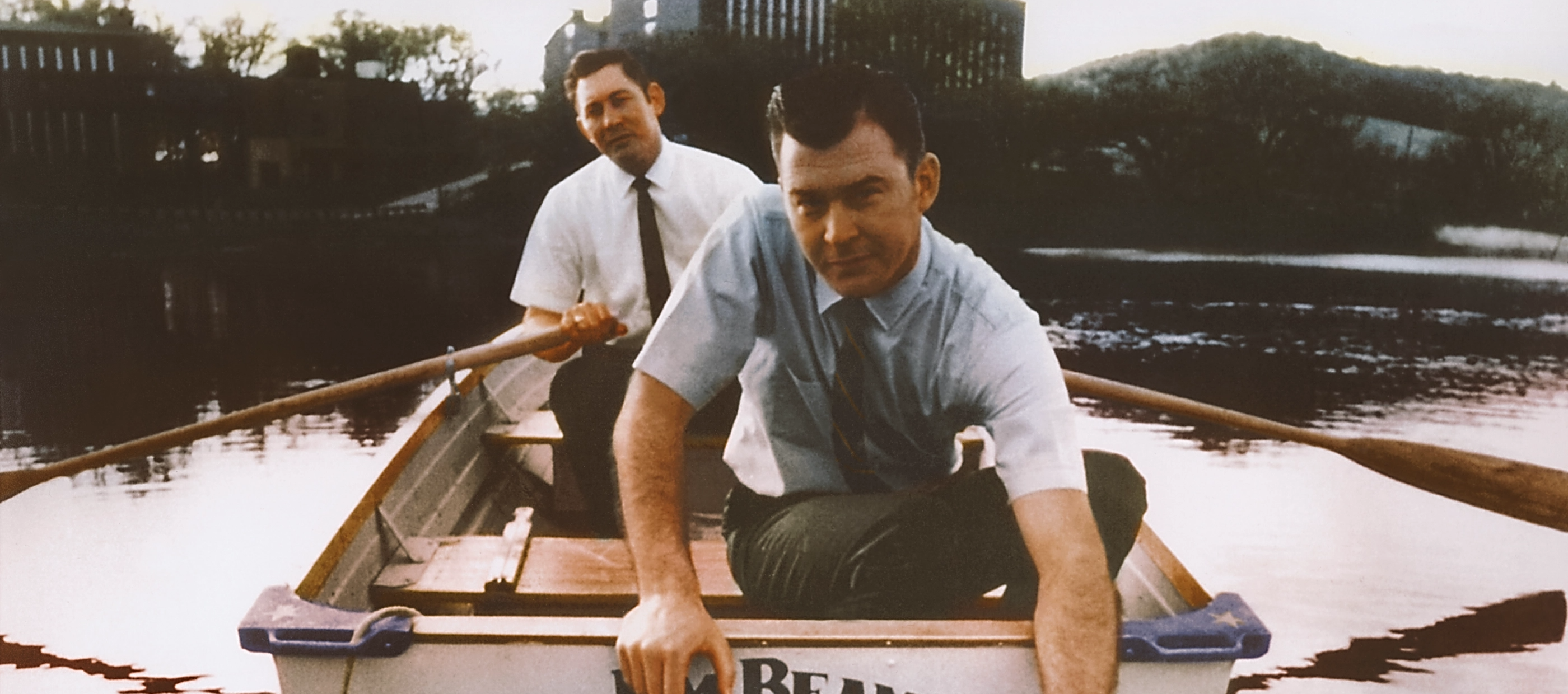 Banner image consisting of two men sailing a boat