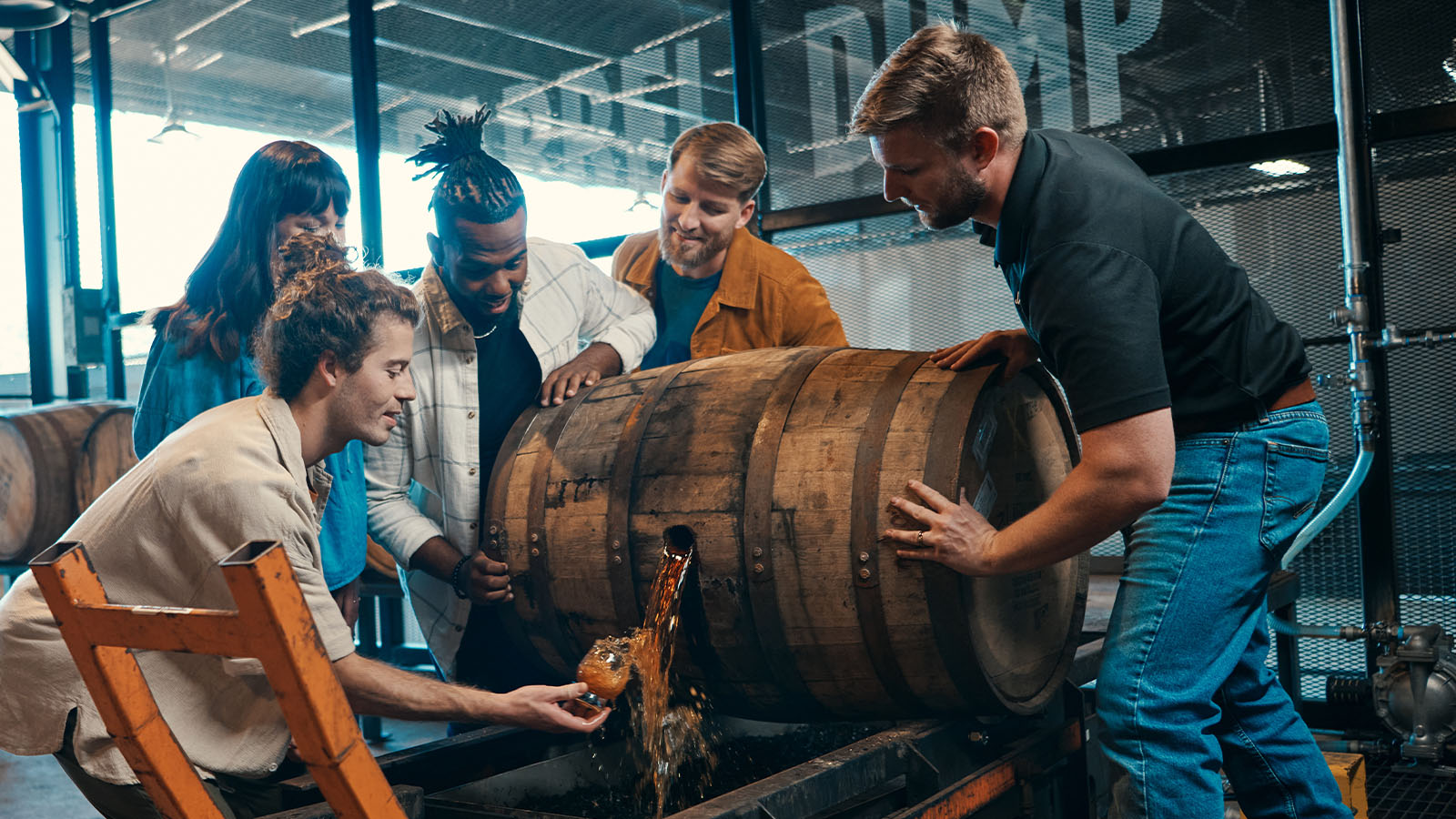 Visitor pouring bourbon from a beaker into a The Thief's Keep bottle at the distillery experience.