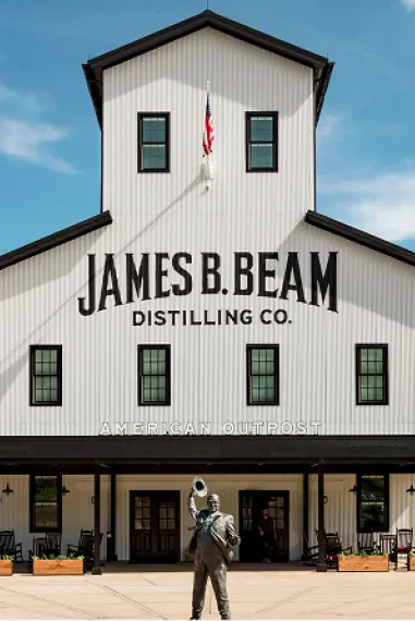 Iconic white and black James B. Beam Distilling Co. American Outpost building with a statue out front.