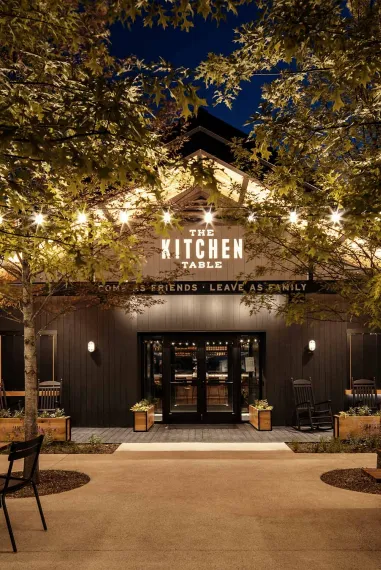 The Kitchen Table restaurant exterior at James B. Beam Distilling Co. at night, lit by string lights.