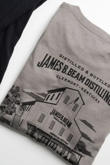 Lifestyle shot of James B. Beam Distilling Co. t-shirts laid out on a table.