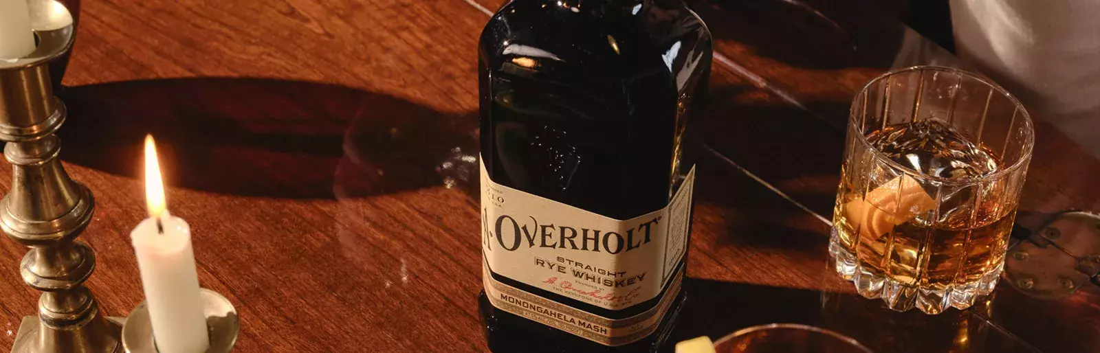 Drink and bottle of American Rye Whisky Old Overholt in a table