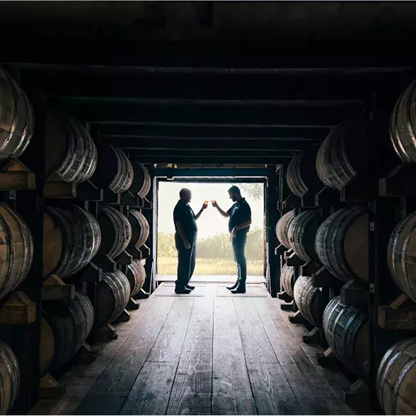 Farmer Distiller and Barrels in Distillery Whisky Old Grand-Dad 