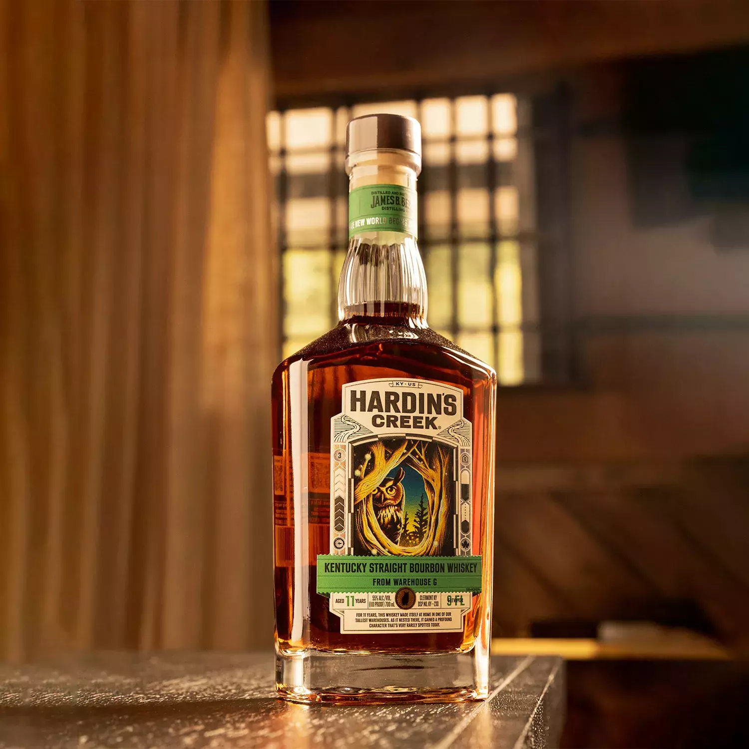 Square whiskey bottle with a dark, artistic label illustration of an owl in the woods Bottle Whisky Hardin's Creek.