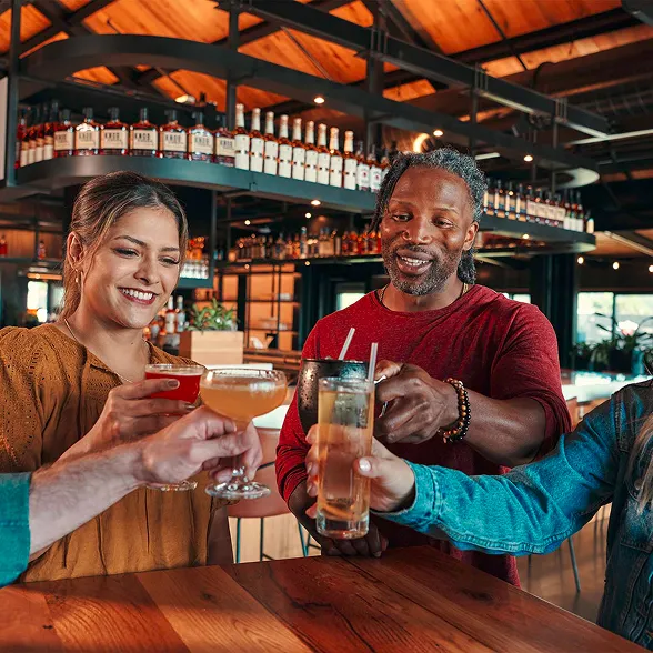 Friends toasting with cocktails at The Kitchen Table restaurant bar at James B. Beam Distilling Co.  Development