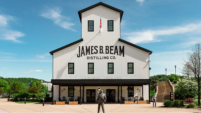 Iconic white and black James B. Beam Distilling Co. American Outpost building with a statue out front.