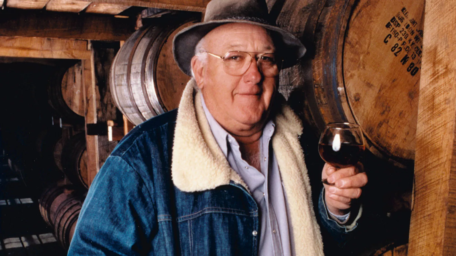 Master Distiller Booker Noe of James B. Beam Distilling Co. holding tasting glass in rackhouse.