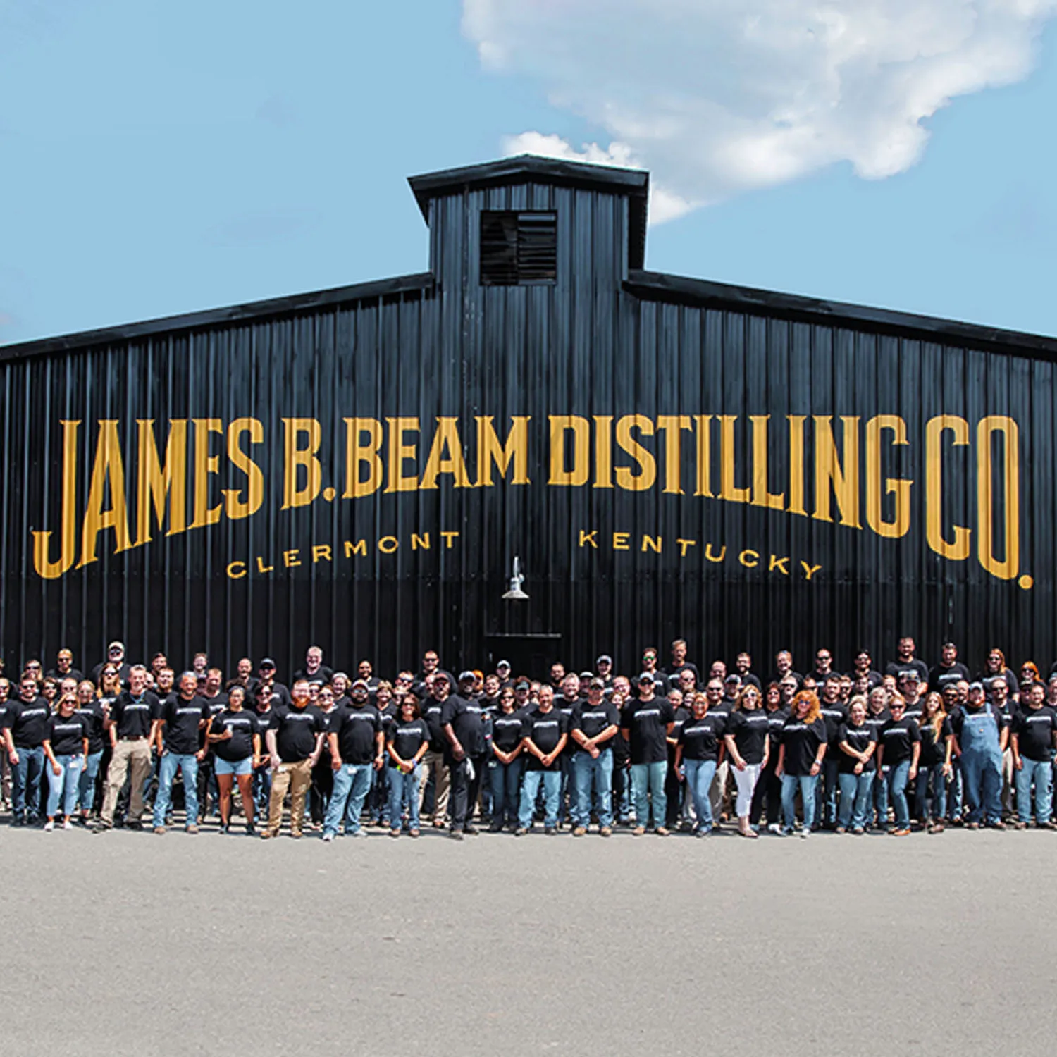 The distillery team at James B. Beam Distilling Co., Clermont, KY, in front of sign.