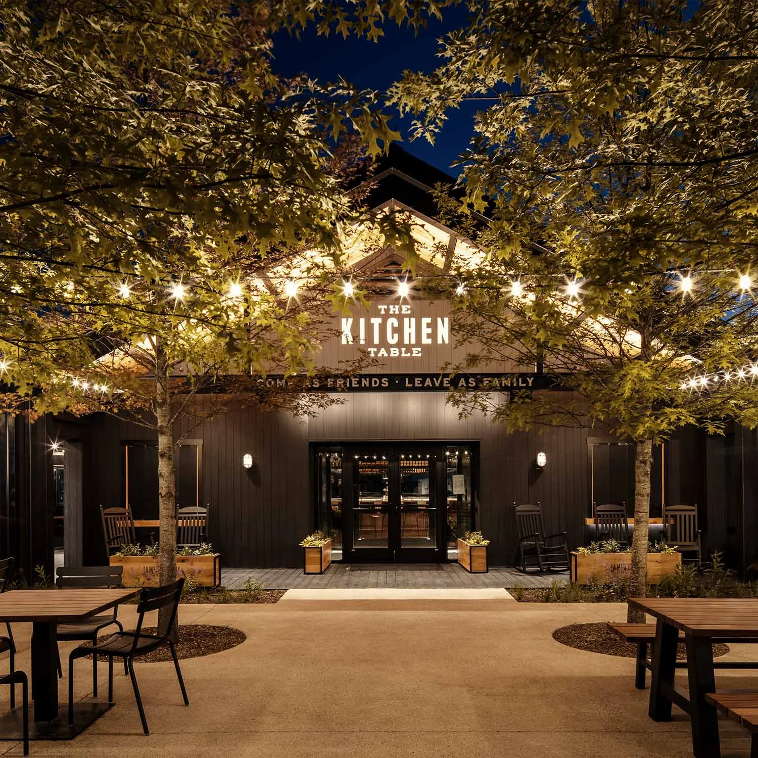 The Kitchen Table restaurant exterior at James B. Beam Distilling Co. at night, lit by string lights.