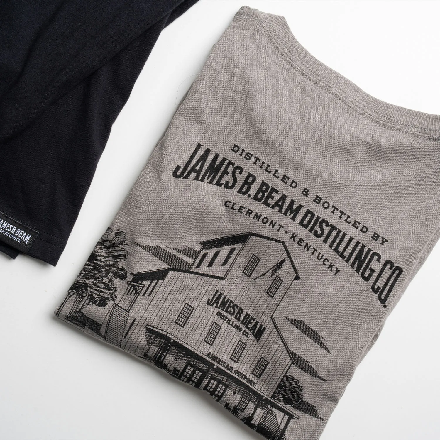 Lifestyle shot of James B. Beam Distilling Co. t-shirts laid out on a table.