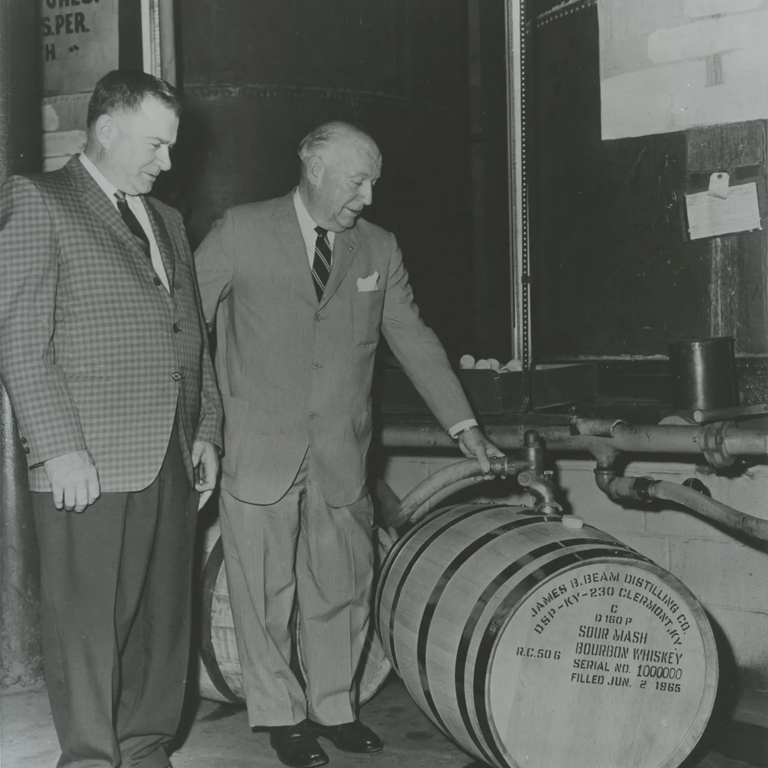 T. Jeremiah Beam and a distiller filling the millionth bourbon barrel. James B. Beam Distilling Co. history.