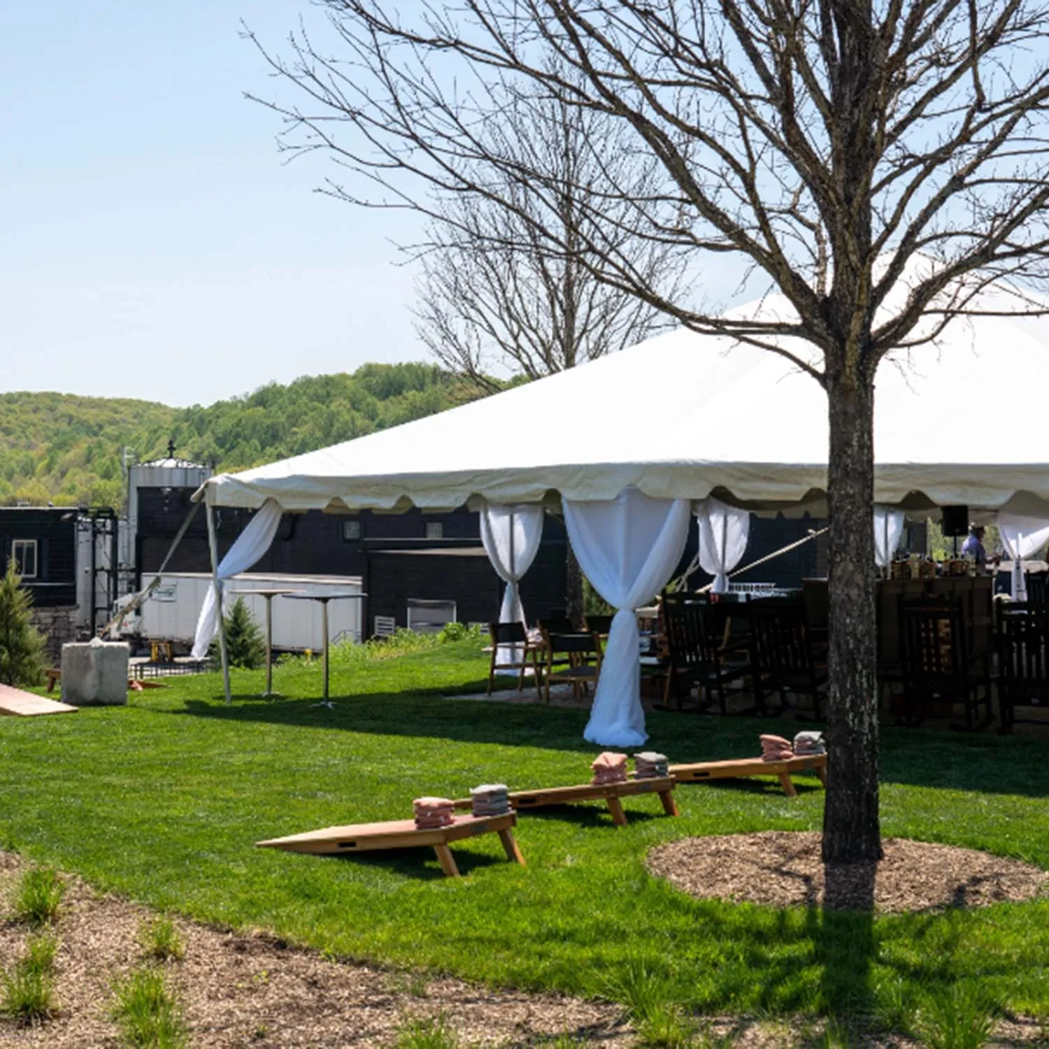 Cornhole (bags) game setup outside a large event tent on the lawn at the James B Beam Distilling Co Campus
