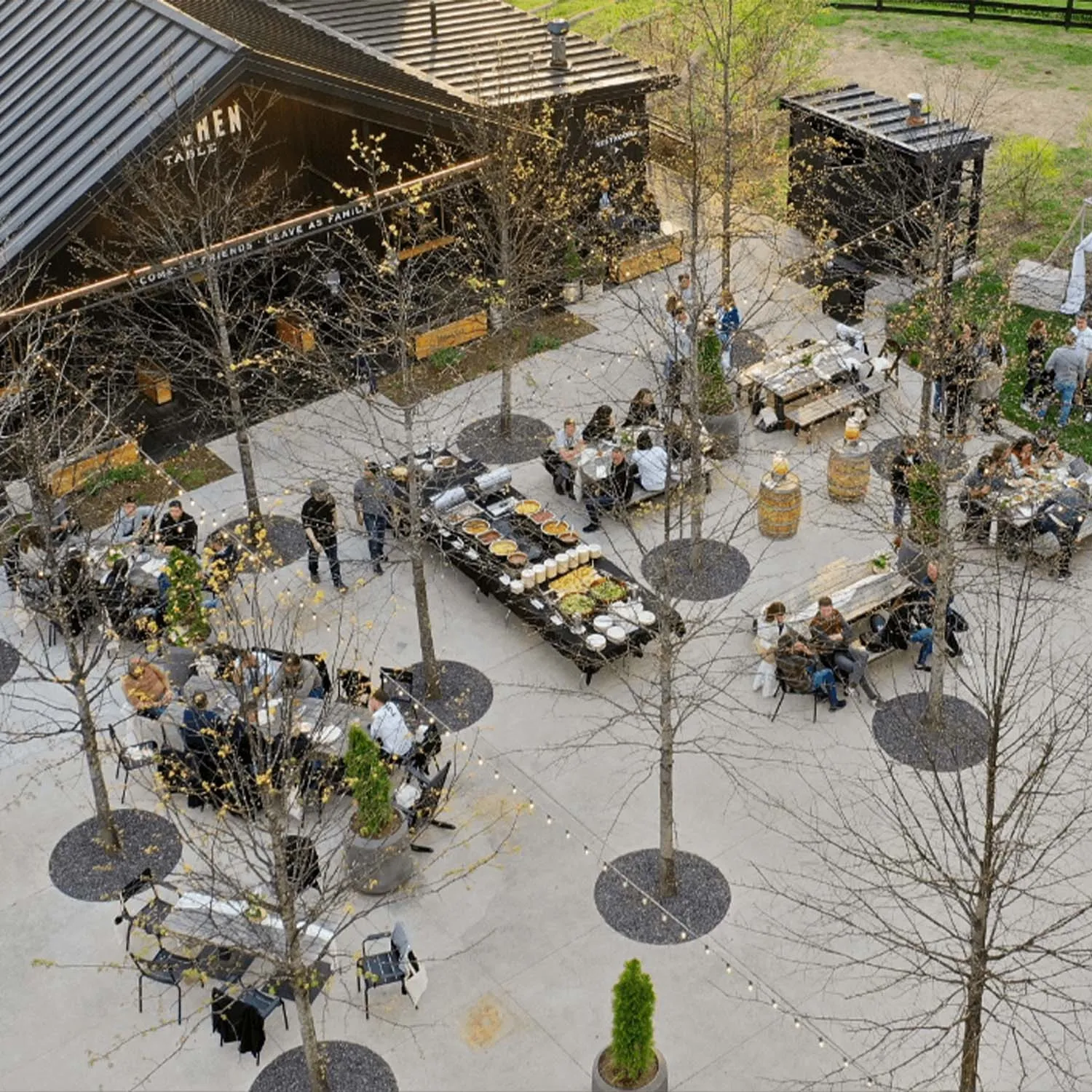 Outdoor seating area and directional sign to The Kitchen Table and American Outpost at the distillery.