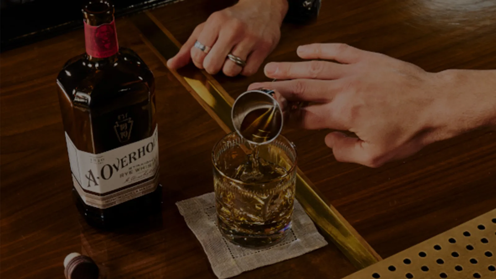 Bottle and man pouring drink of American Rye Whisky Old Overholt