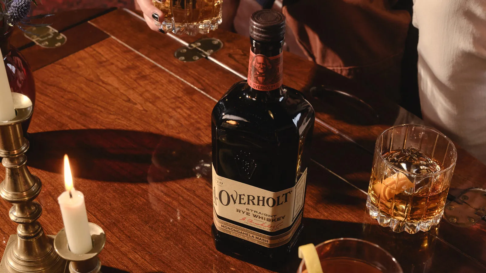 Two men, Fred and Freddie Noe, from James B. Beam Distilling Co., one inspecting a glass of bourbon in the distillery