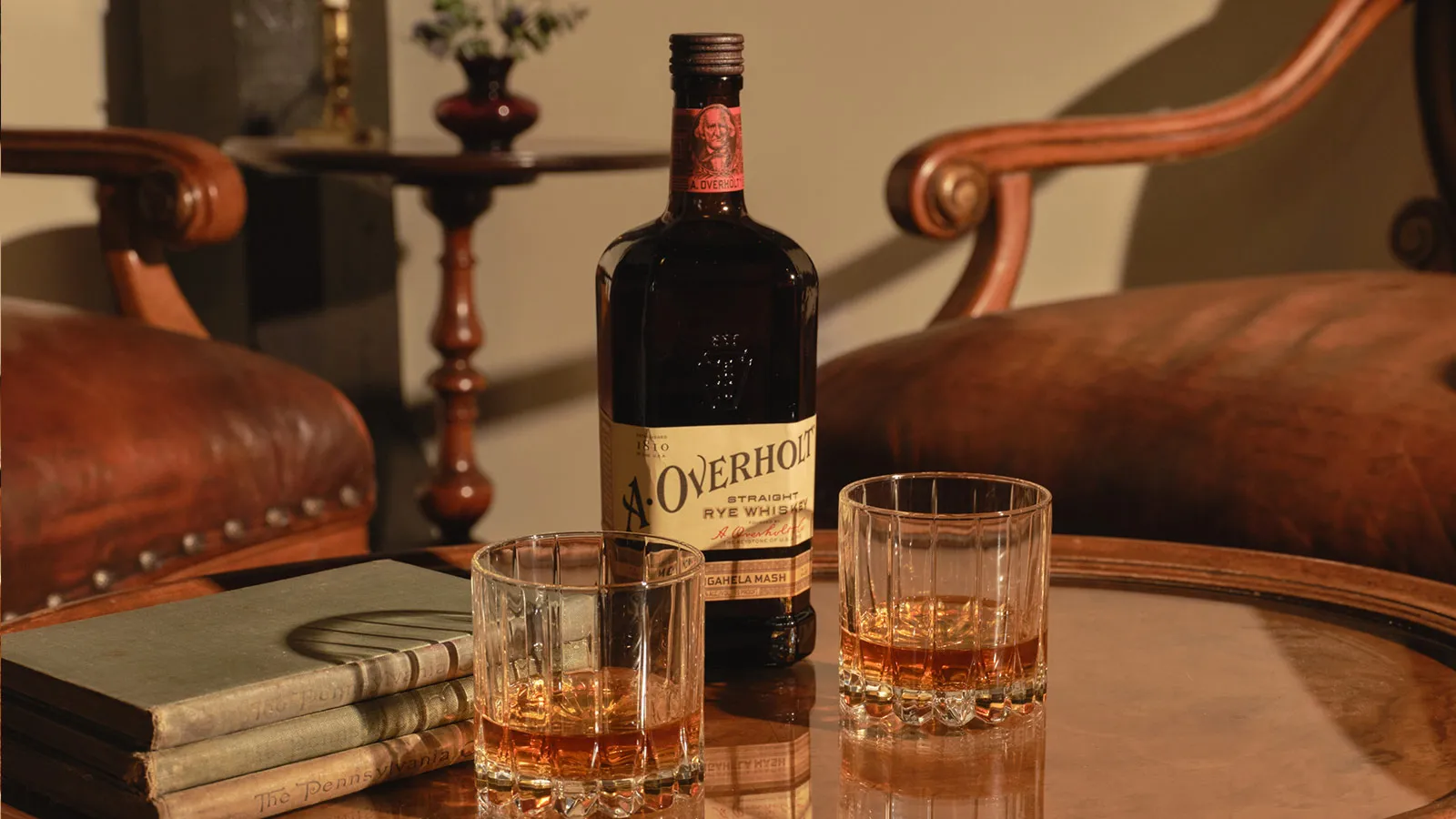 Whiskey bottle and two glasses on a table of American Rye Whiskly Monongahela Mash Old Overholt