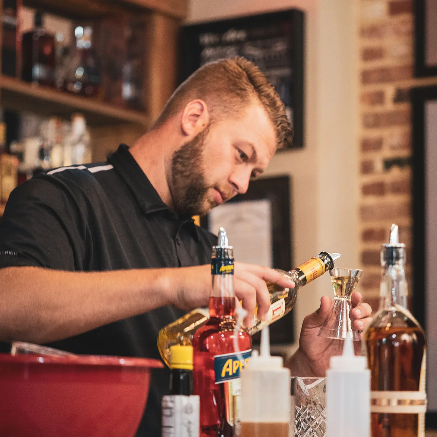 Freddie Noe bartending at a James B. Beam Distilling Co. event, carefully pouring a spirit measure. 