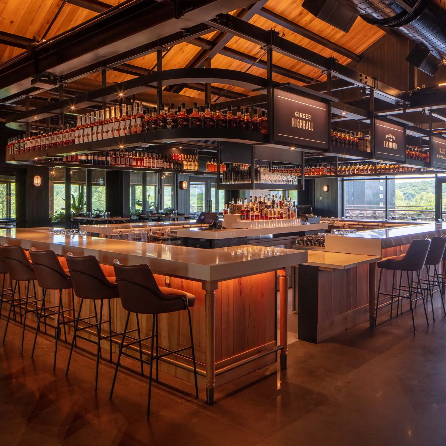 Main bar area of The Kitchen Table Restaurant with wood ceiling and bourbon bottle display.