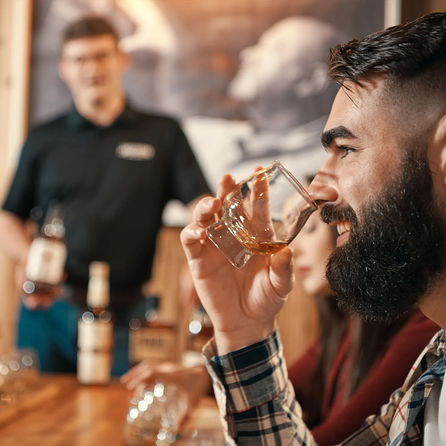 Man smiling while nosing a glass of whiskey during a tasting experience at the James B. Beam distillery.